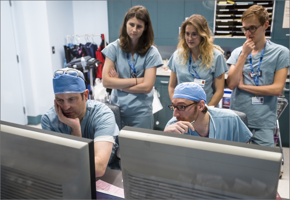 A group of Medventions fellows gather to observe in a clinical setting.