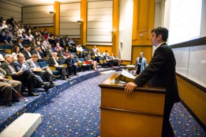 Inside a packed lecture theatre, Medventions Toronto attendees listen to a lecturer.
